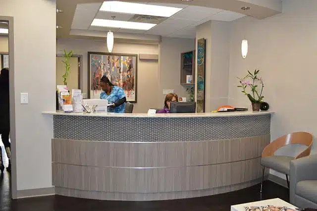 The front desk of Prerimeter Plastic Surgery office with two staff members.