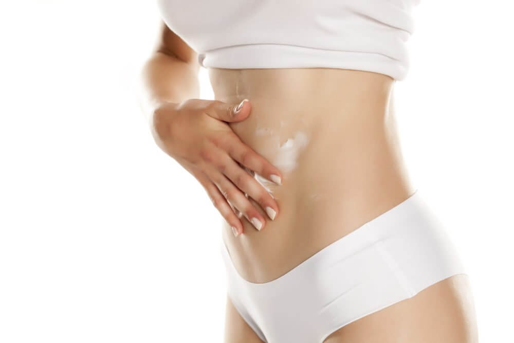 Patient using cream on her tummy post Minimize Tummy Tuck Scar treatment