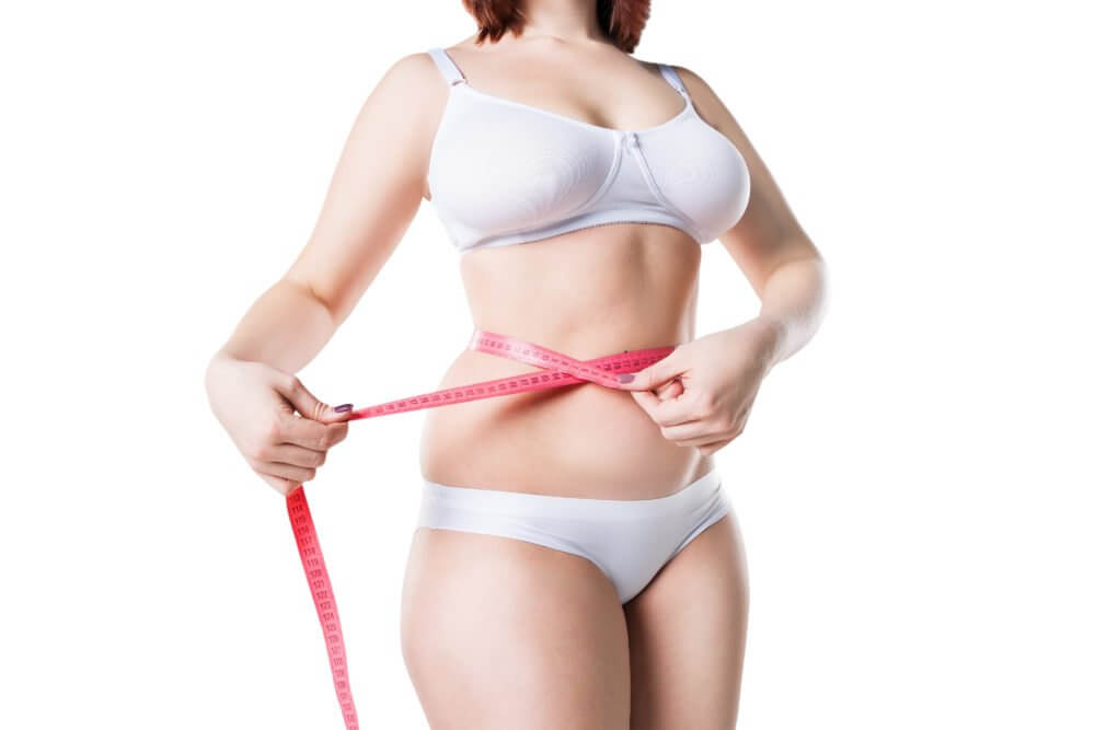 Measuring the results of a Mommy Makeover on a woman's abdomen using tape